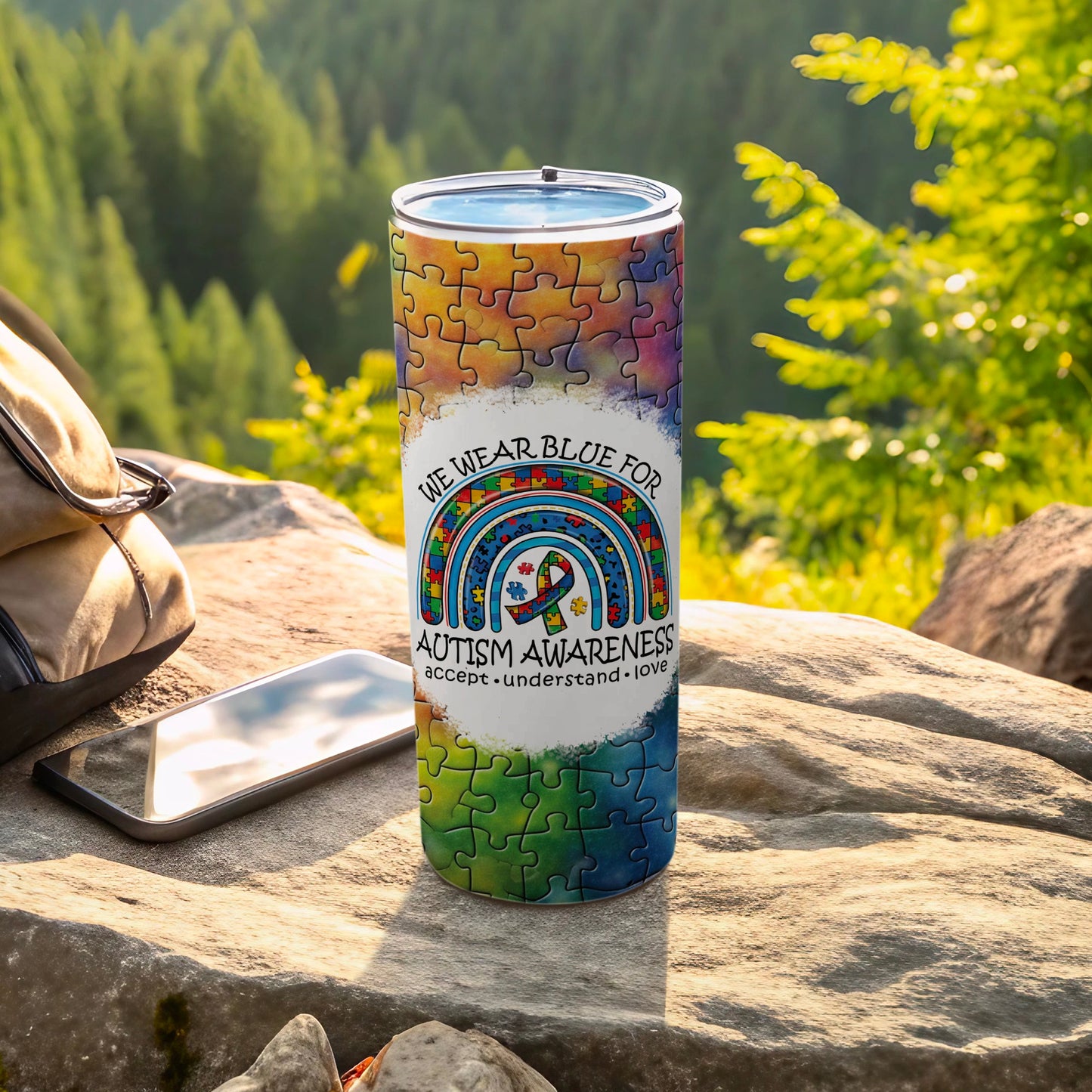 "We Wear Blue for Autism Awareness" tumbler with rainbow puzzle design.