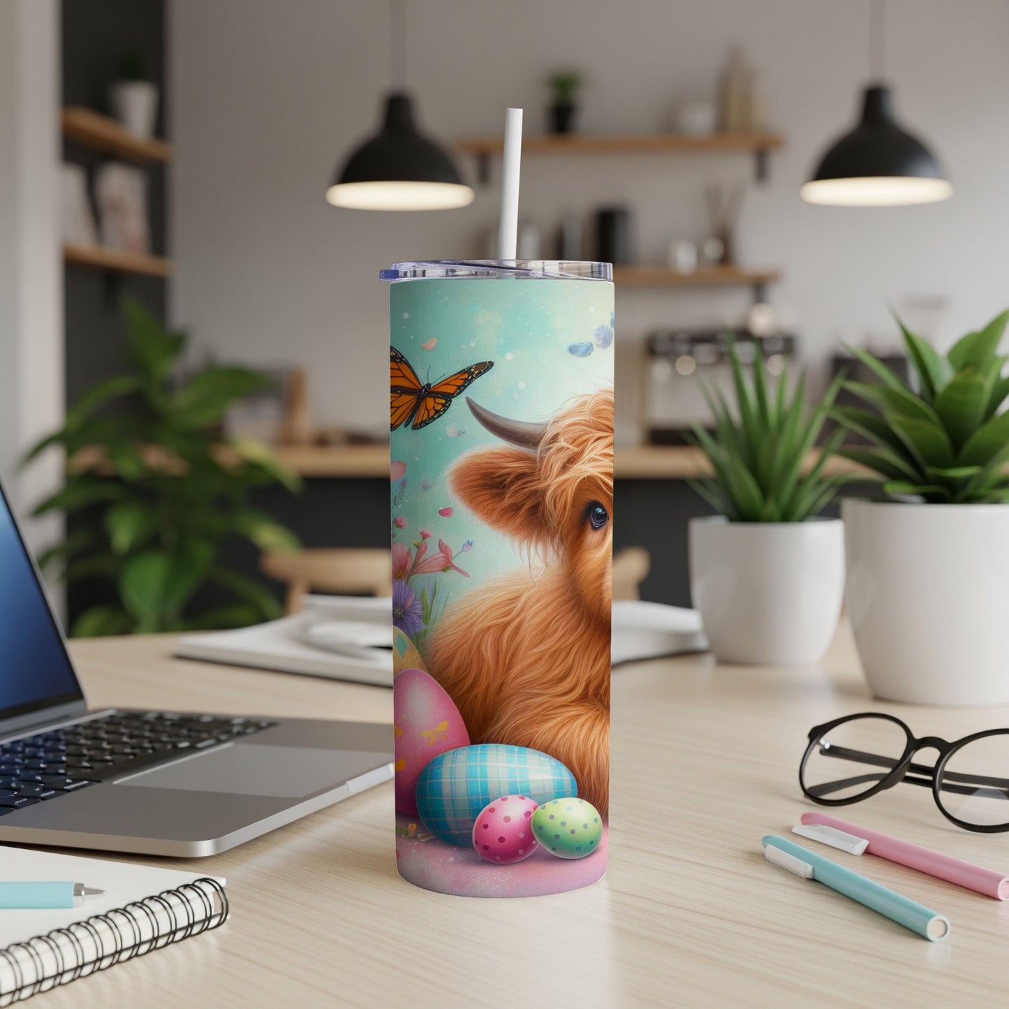 Highland cow with Easter eggs and butterfly, on a blue, teal, and pink speckled tumbler.