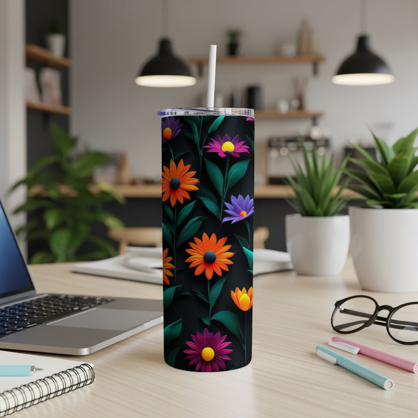 Black tumbler with vibrant orange and purple floral design and straw.