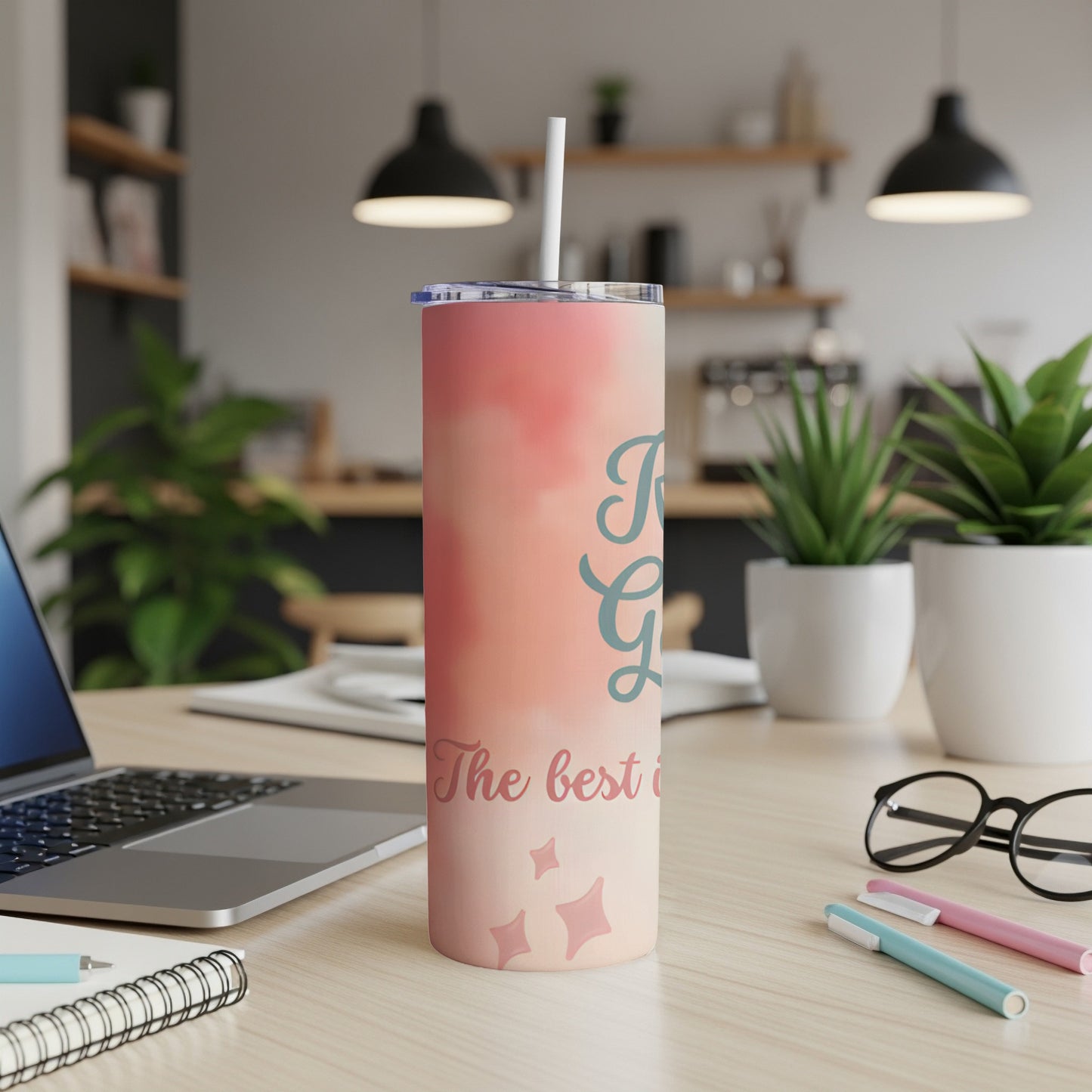 Pink tumbler with "The best gift" text and scattered stars on a desk.
