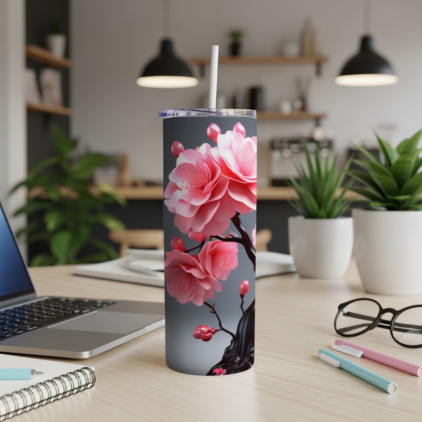 Pink cherry blossoms on a grey tumbler with a white straw.