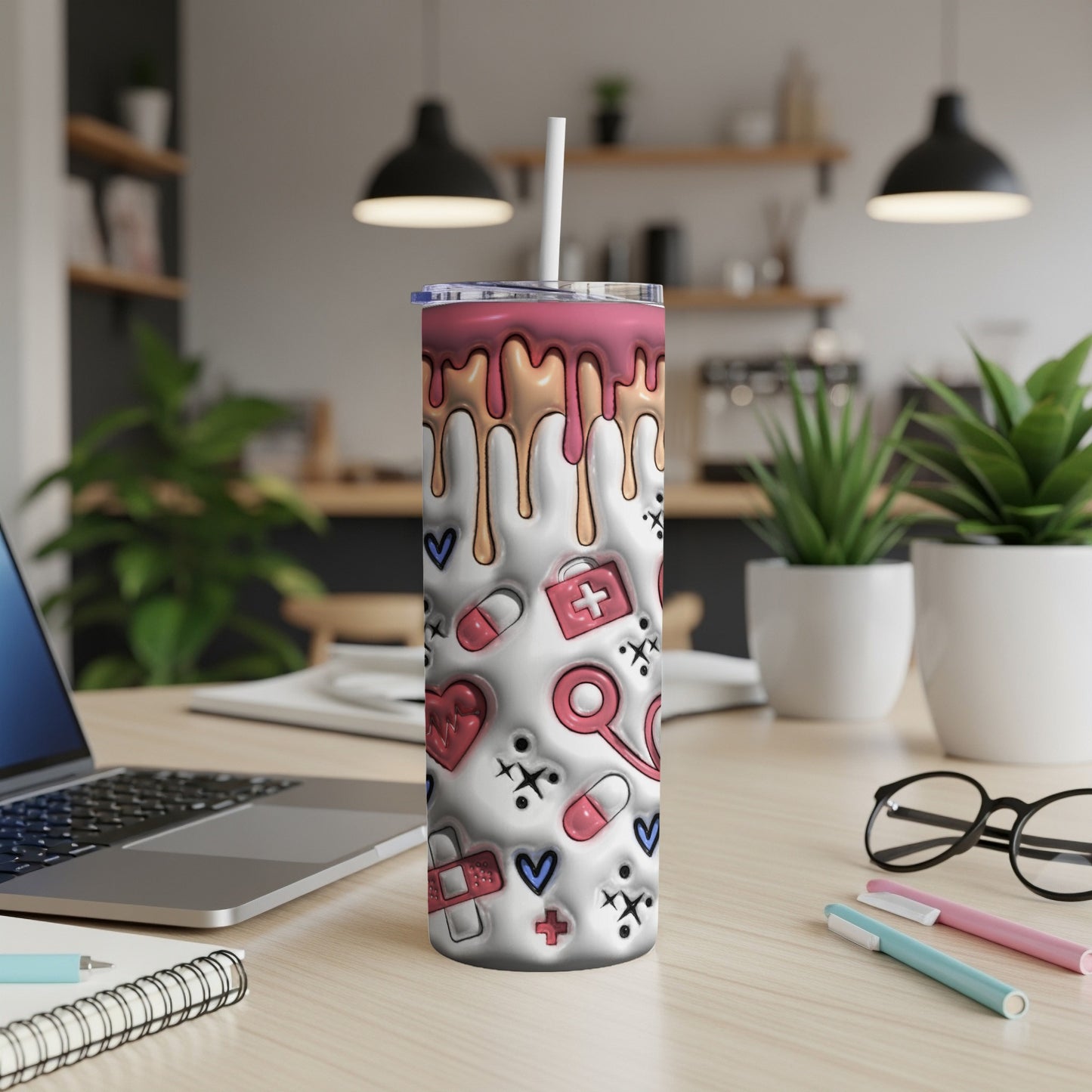 White tumbler with medical icons and pink drips, on a desk.