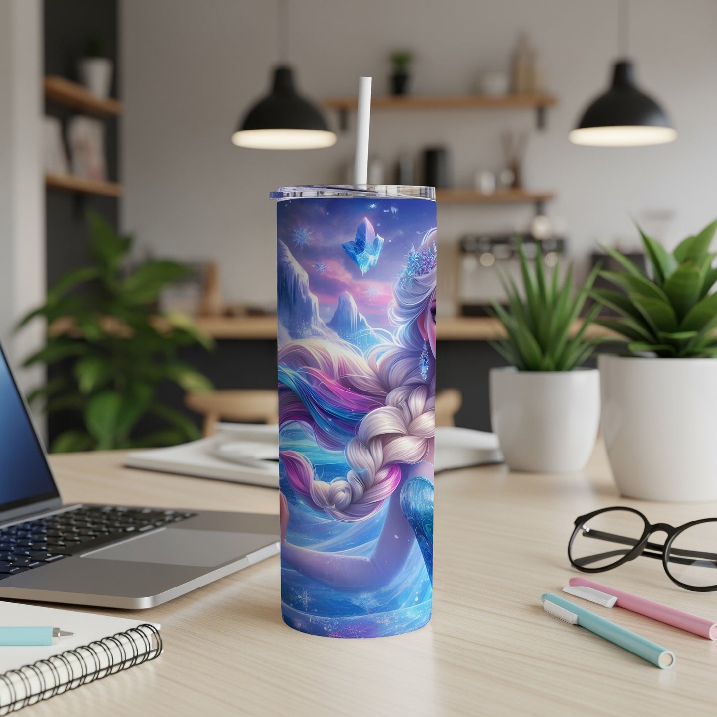 Blue tumbler with icy mermaid design, white straw, on a desk.