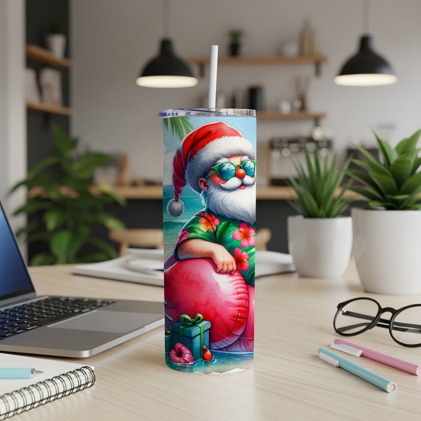 Santa Claus in Hawaiian shirt on flamingo float, holding straw, on a desk.