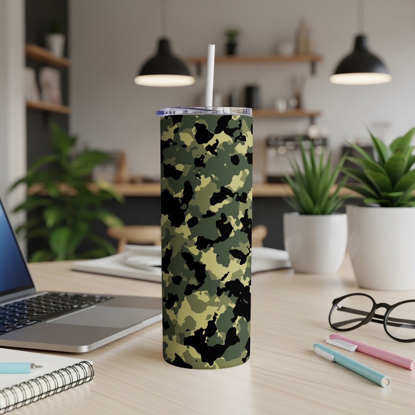 Camouflage pattern tumbler with white straw on a wooden desk.