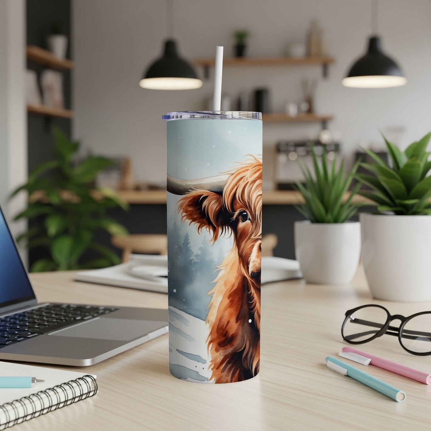 Tall tumbler with a watercolor Highland cow face against a snowy forest.