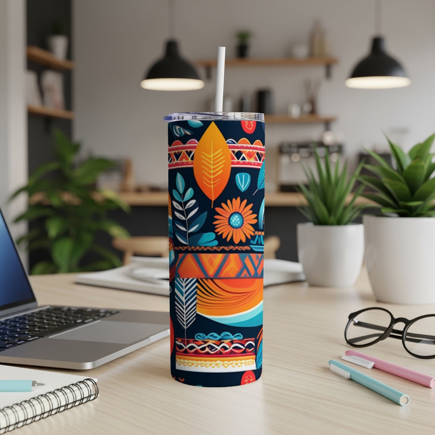 Tumbler with colorful tribal and floral patterns and a straw.