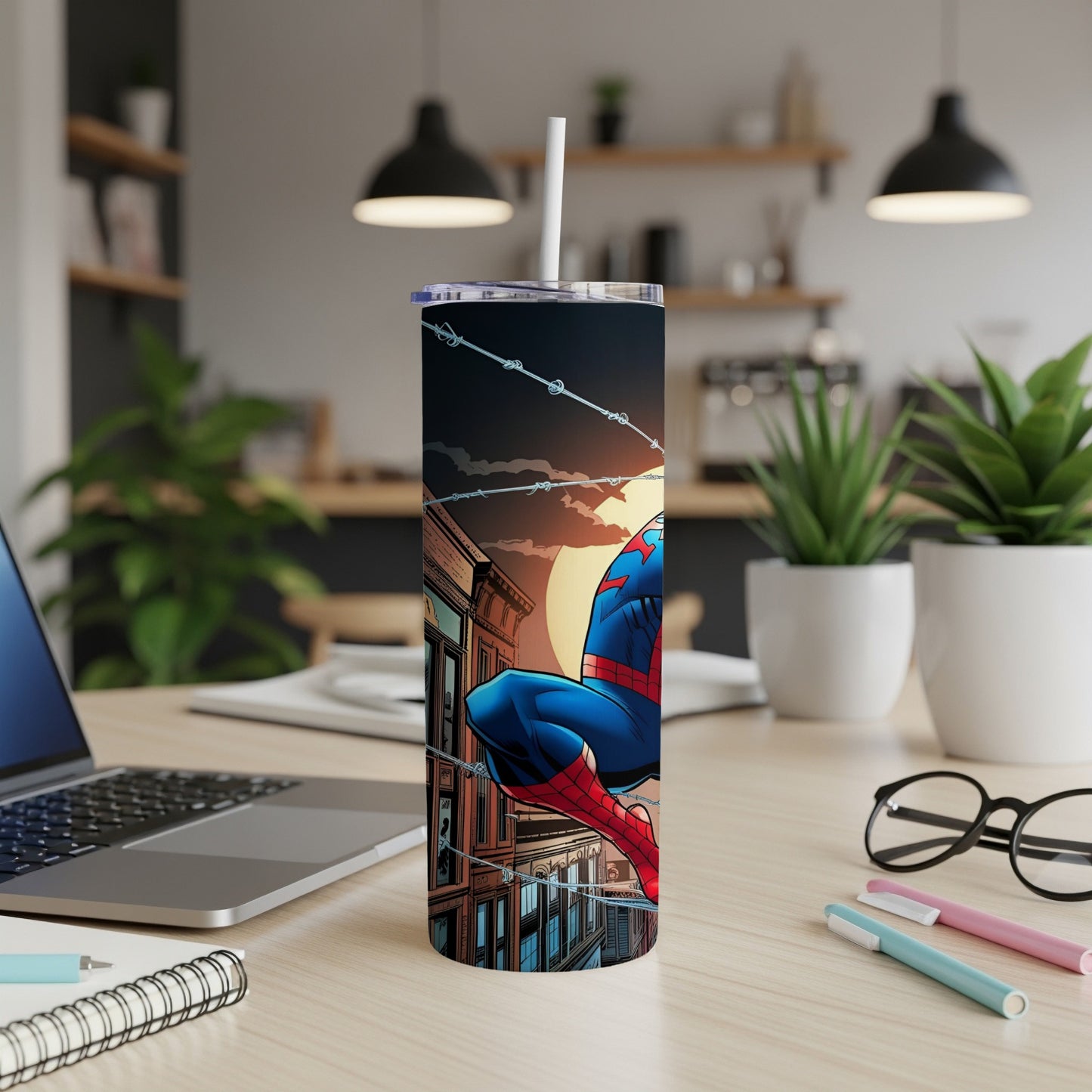 Spiderman tumbler with cityscape background on a desk.