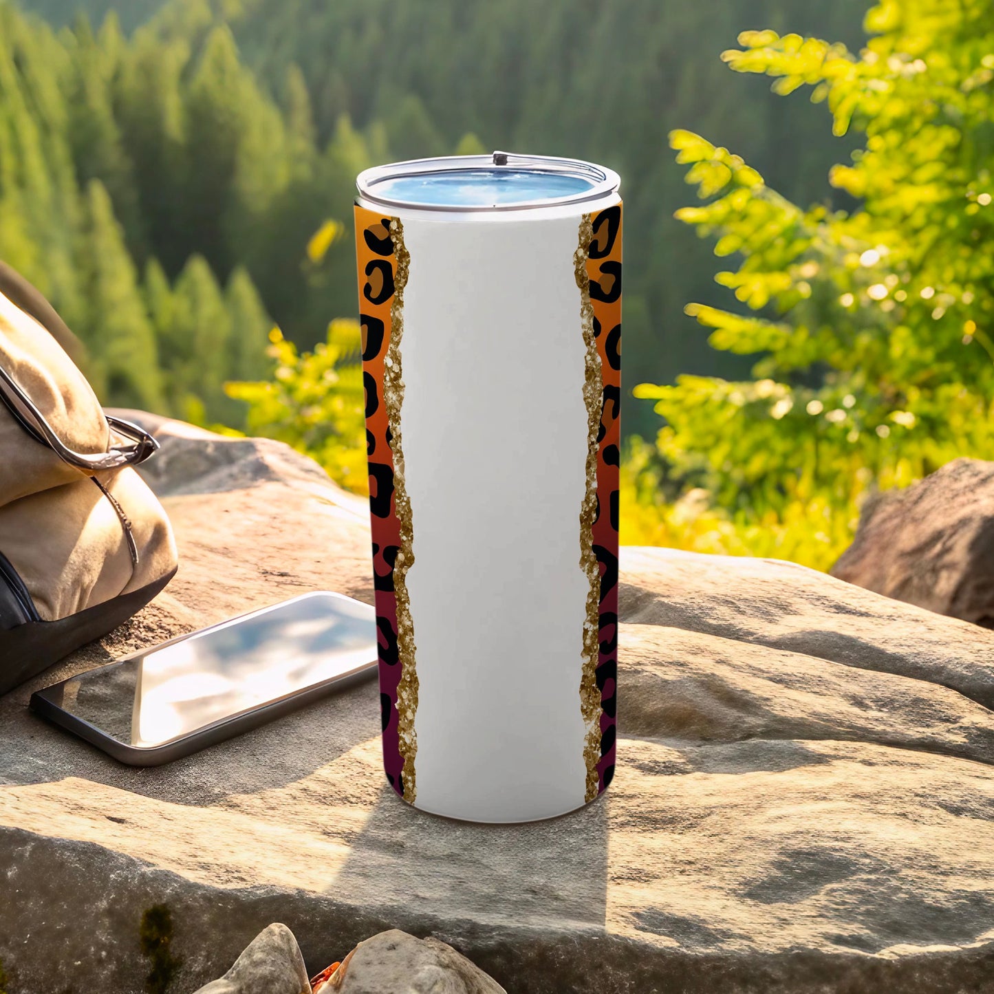 Leopard print tumbler with orange gradient on a rocky surface outdoors.