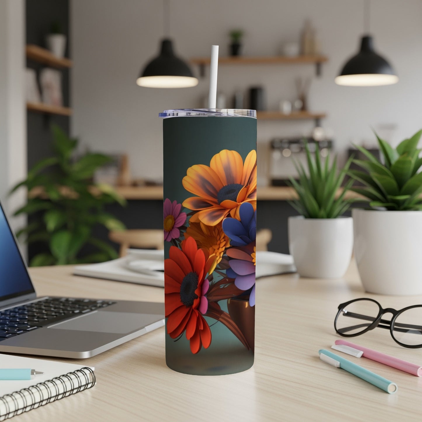 Floral pattern on a dark tumbler with a straw, on a desk.