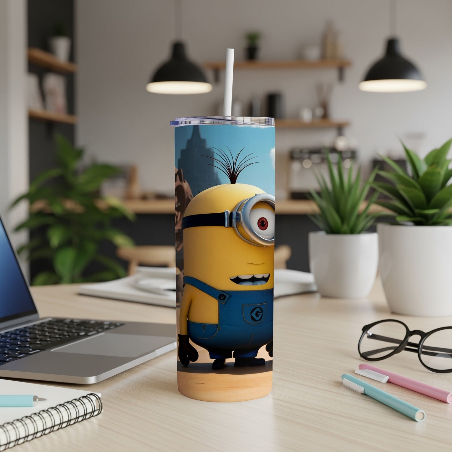 Minion character on a yellow tumbler with a straw, on a desk.