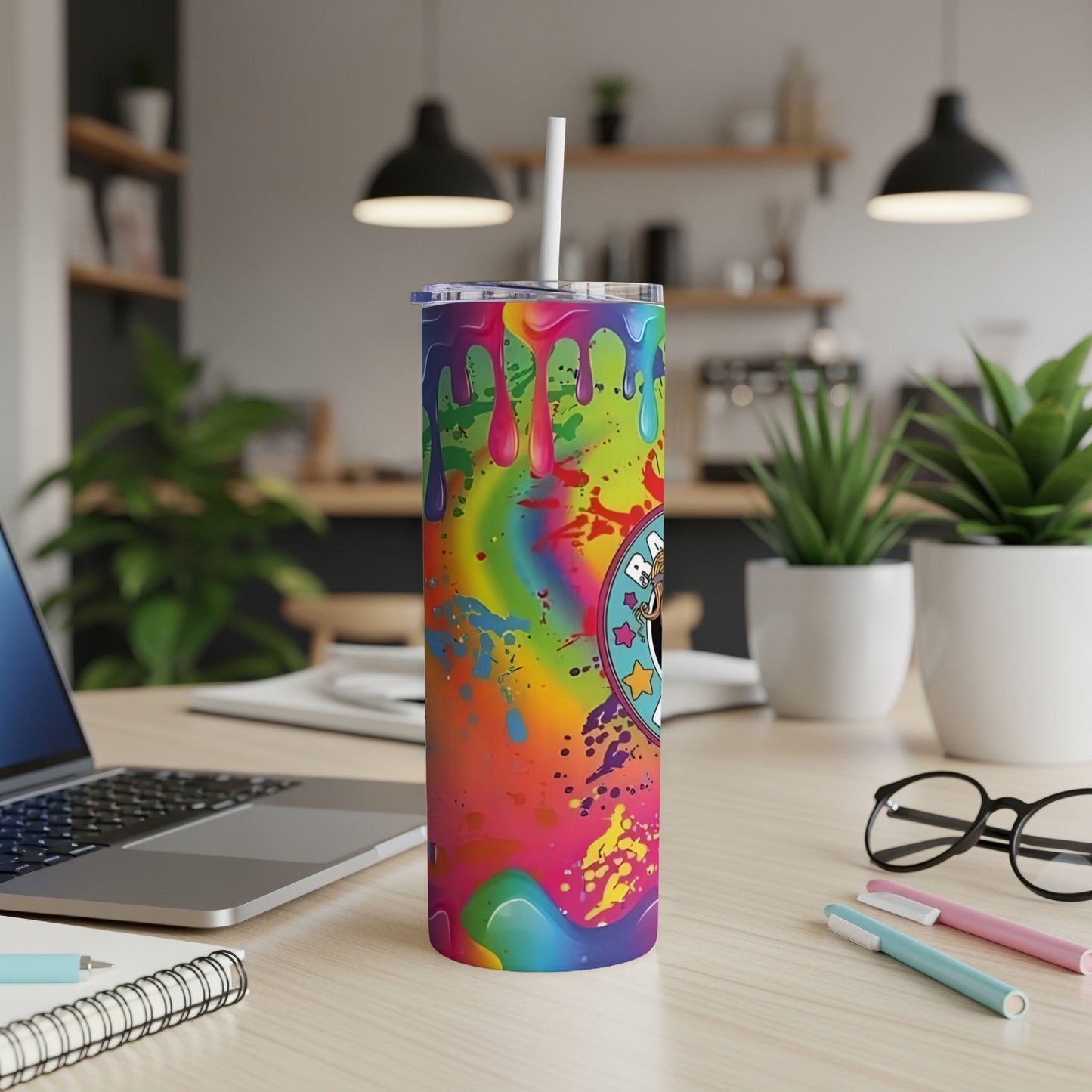 Rainbow splatter tumbler with black and white cartoon character design.