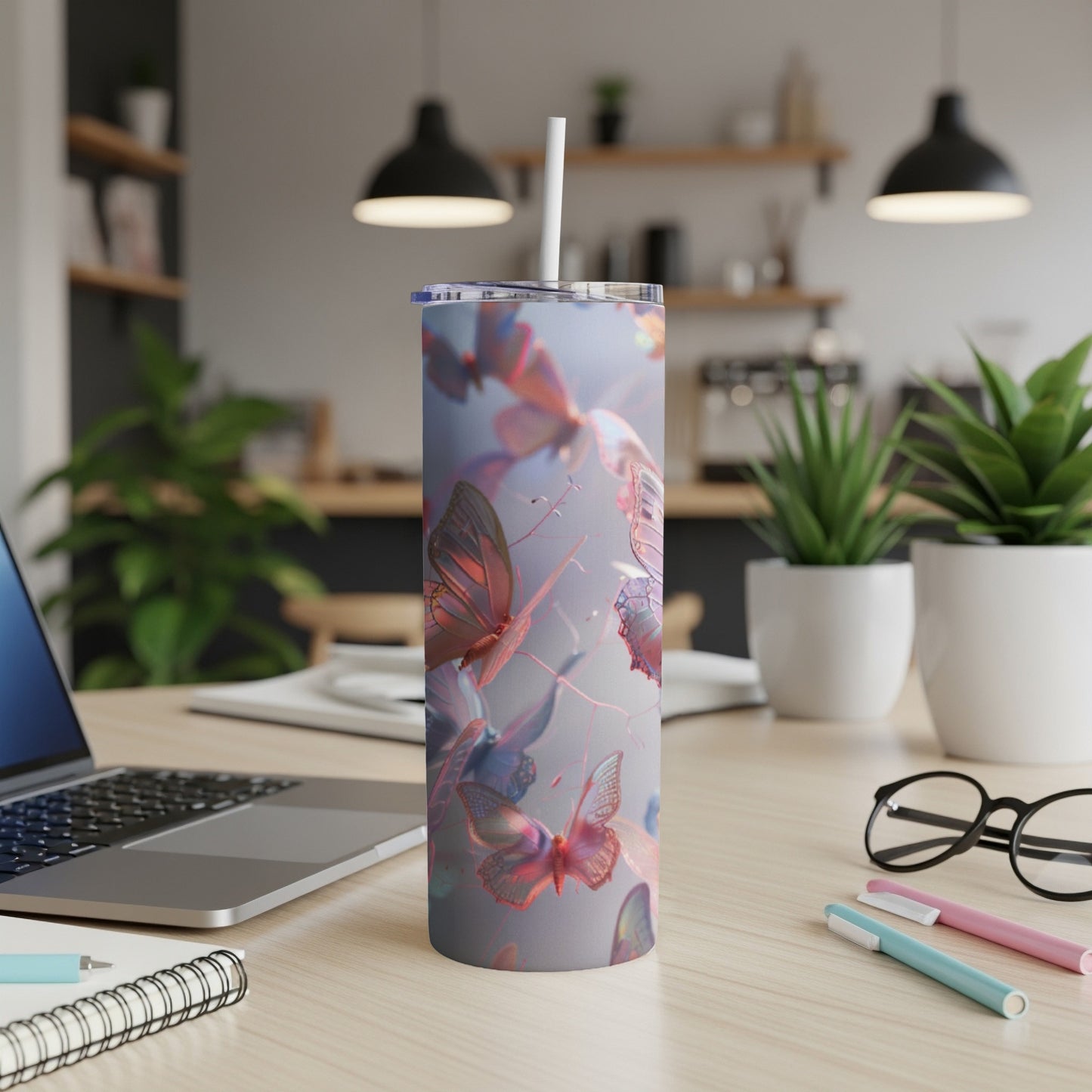 Tumbler with pastel butterflies and abstract background on a desk.