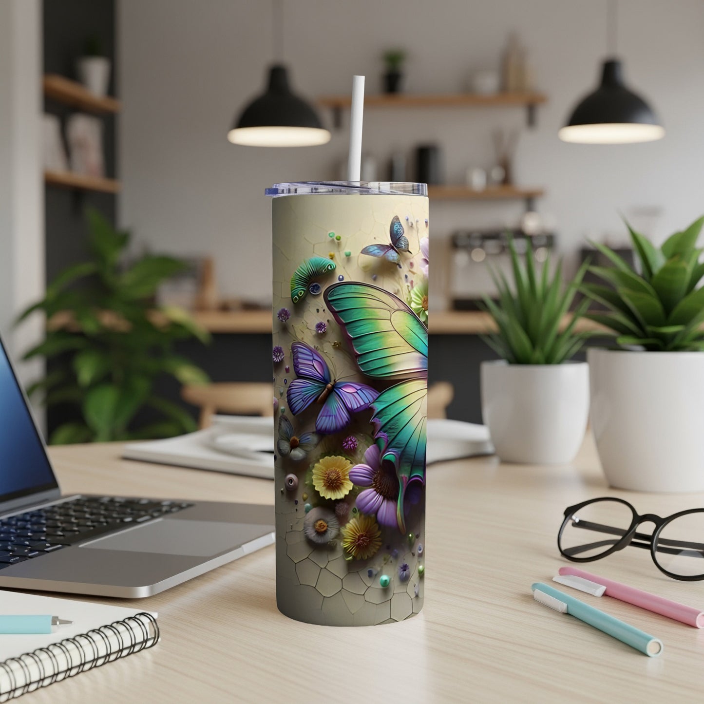 Tumbler with colorful butterfly and floral designs on a desk.