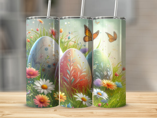 Three Easter eggs decorated with floral patterns and butterflies, surrounded by grass and flowers.
