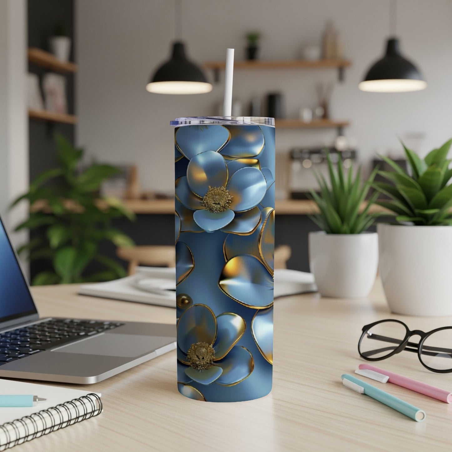 Blue floral tumbler with gold accents on a desk.