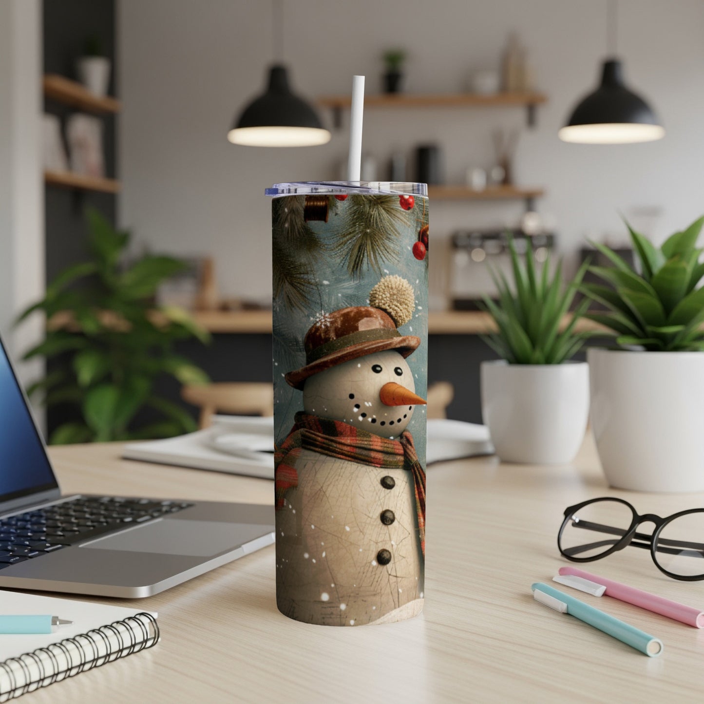 Snowman tumbler with checkered scarf and knit hat in a cozy setting.