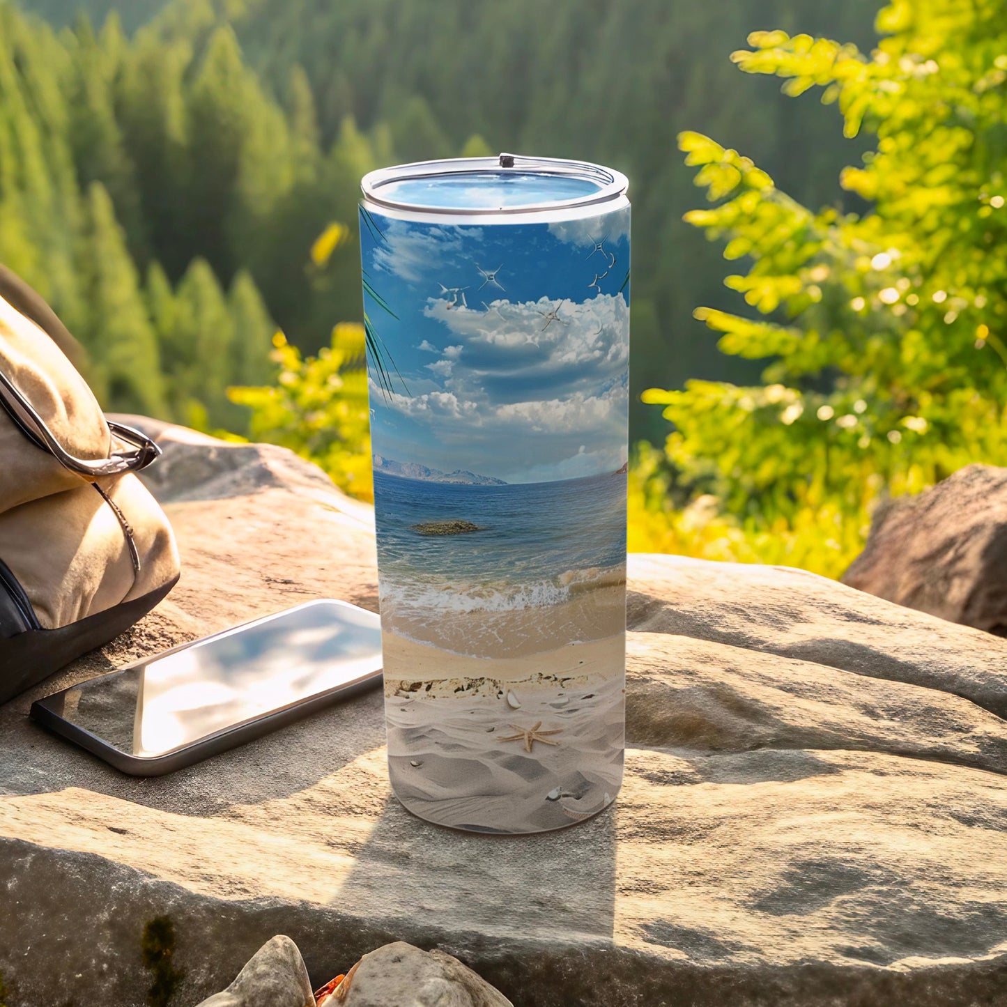 Beach scene on a stainless steel tumbler with a smartphone and bag.