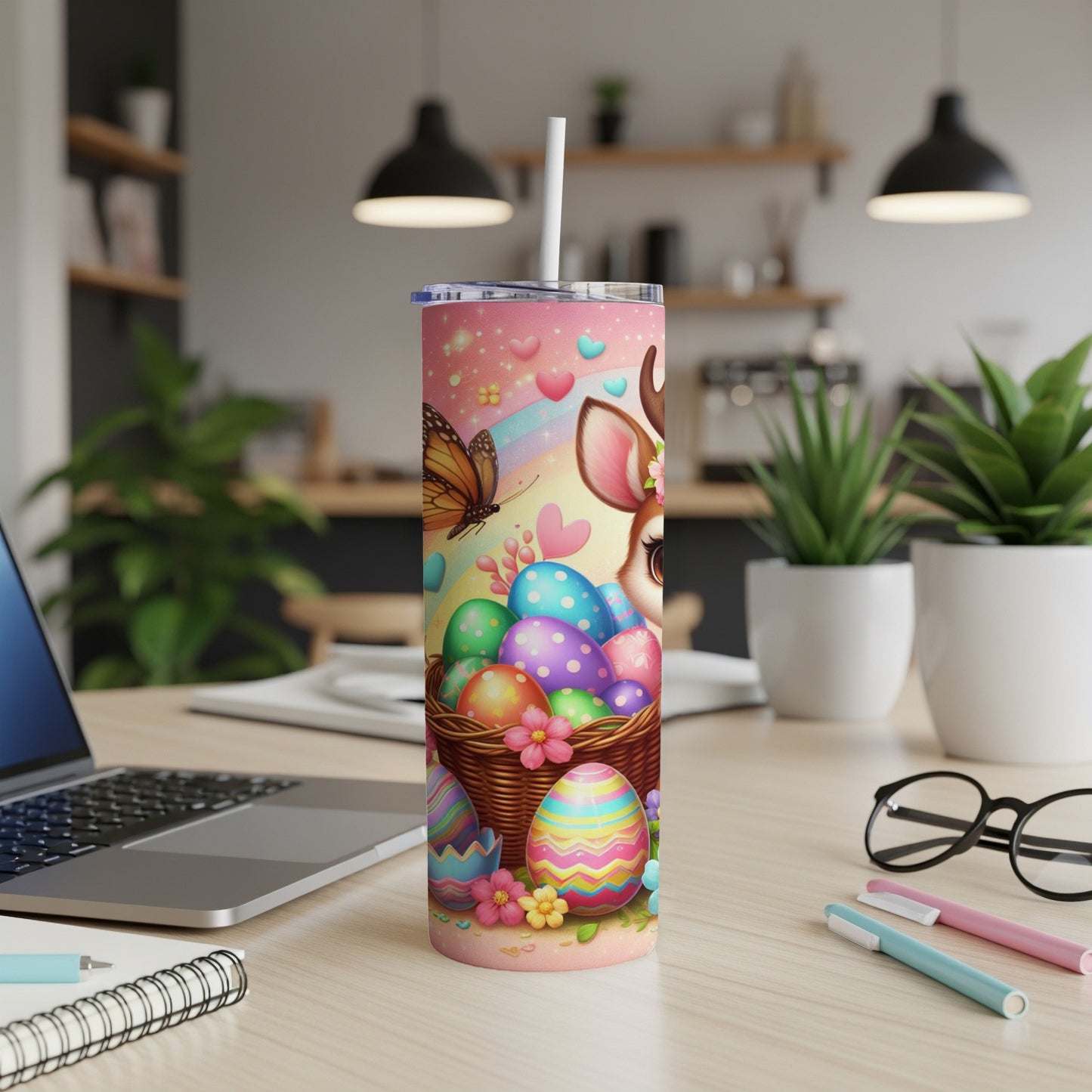 Easter tumbler with colorful eggs, a deer, and a butterfly on a desk.