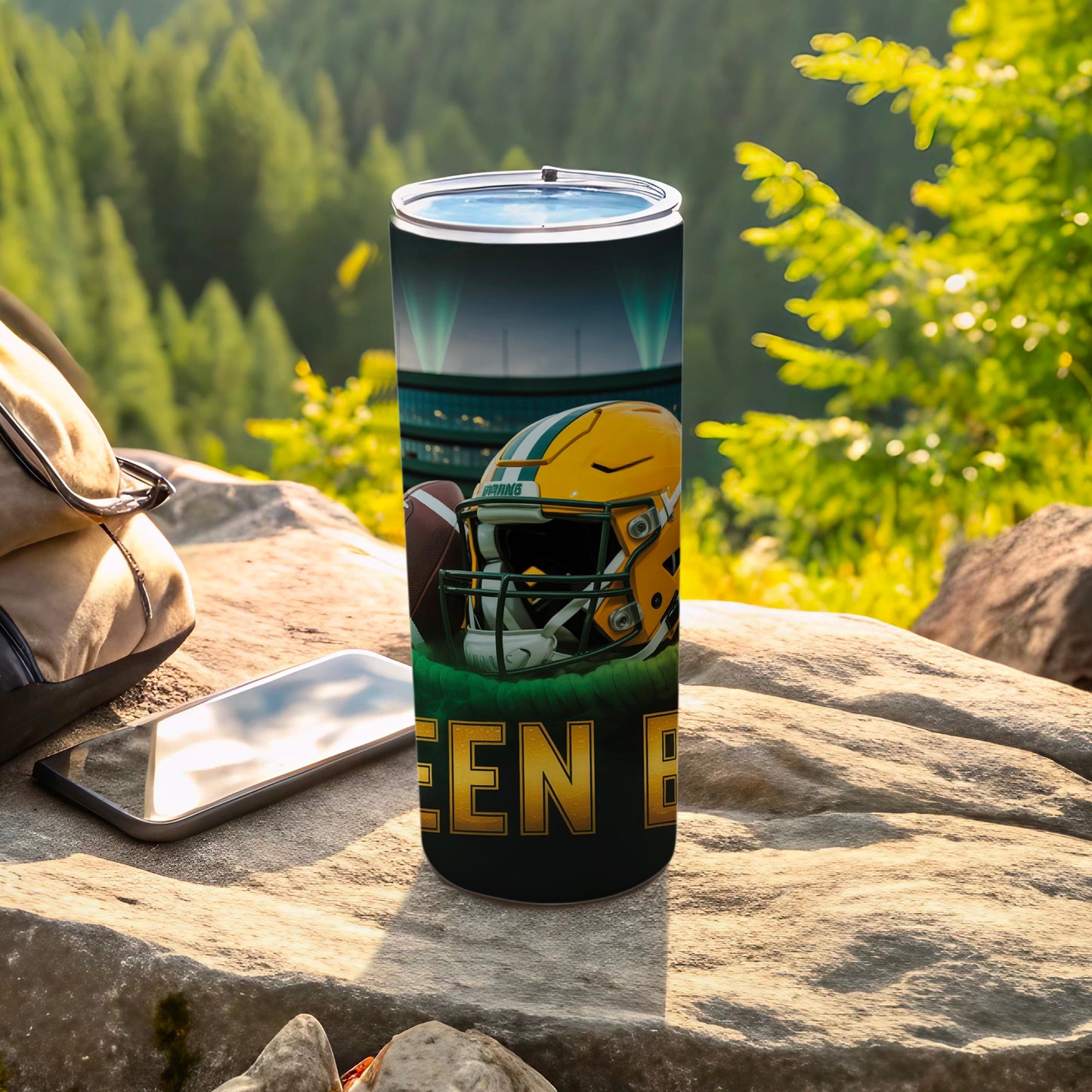 Green Bay Packers helmet and football on a tumbler with stadium background.