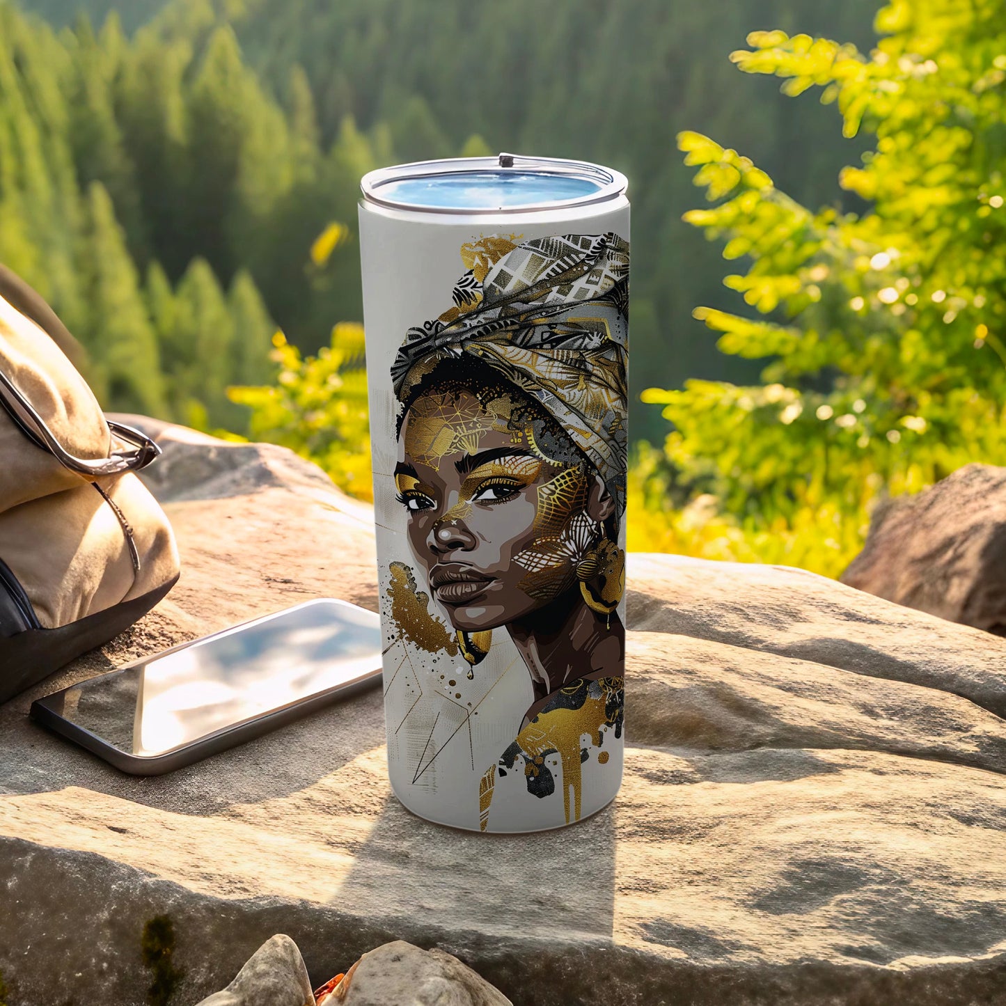 White tumbler with intricate gold and black abstract art of a woman's face.
