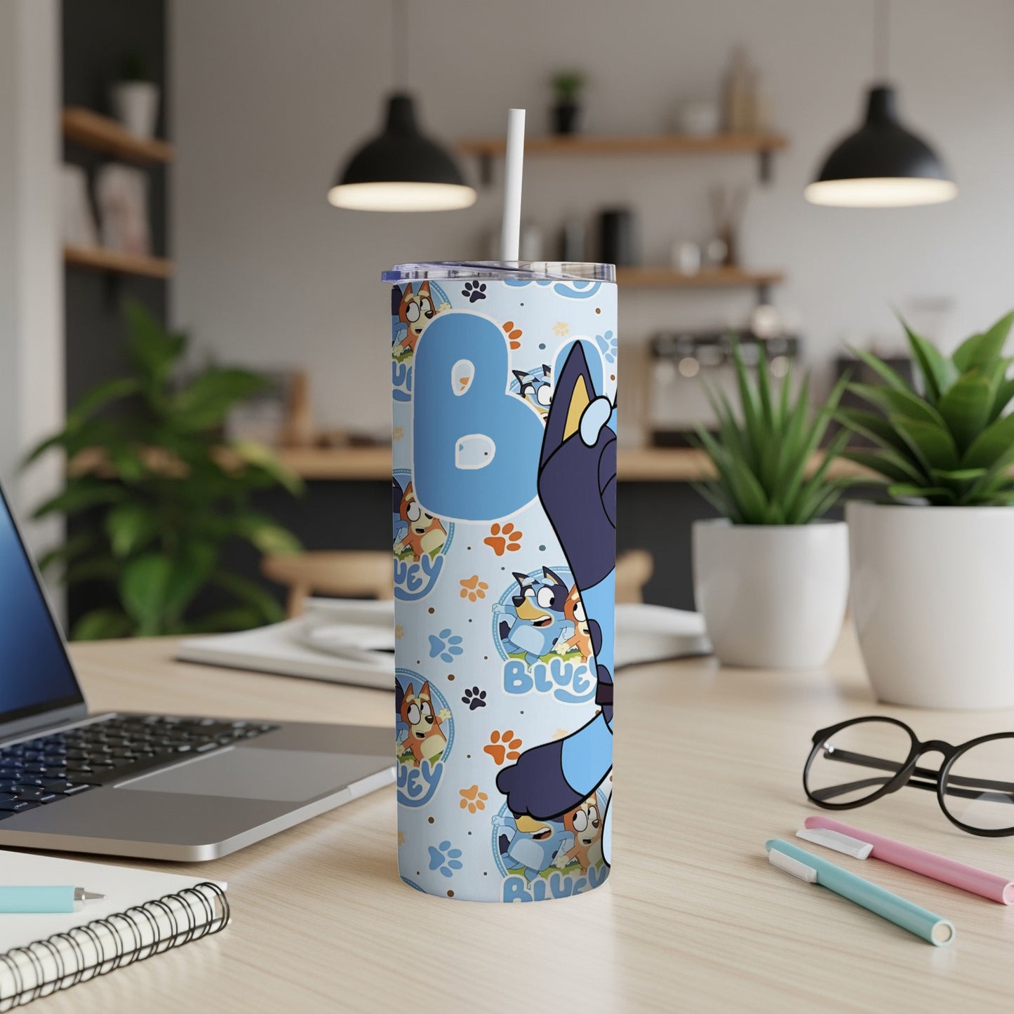 Bluey character tumbler with straws and laptop on desk.