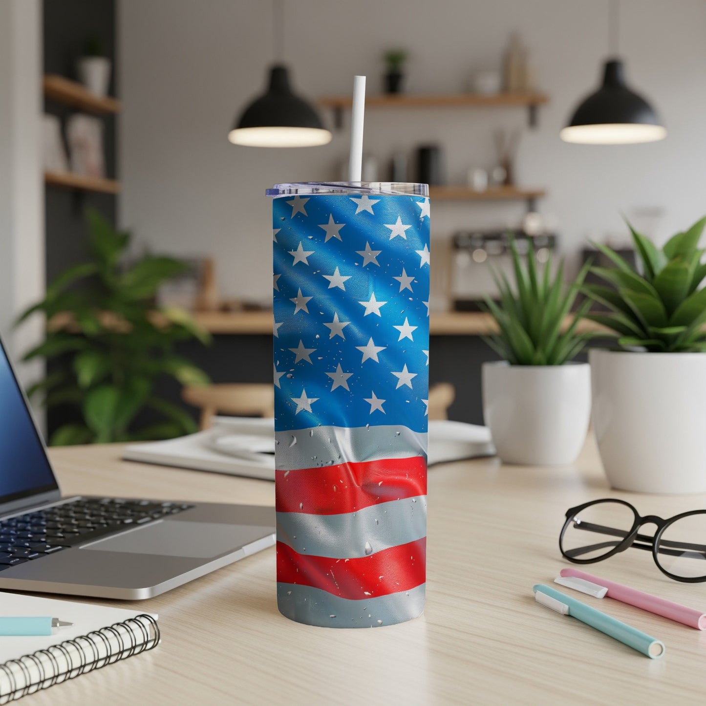 American flag tumbler with water droplets on a desk with a laptop.