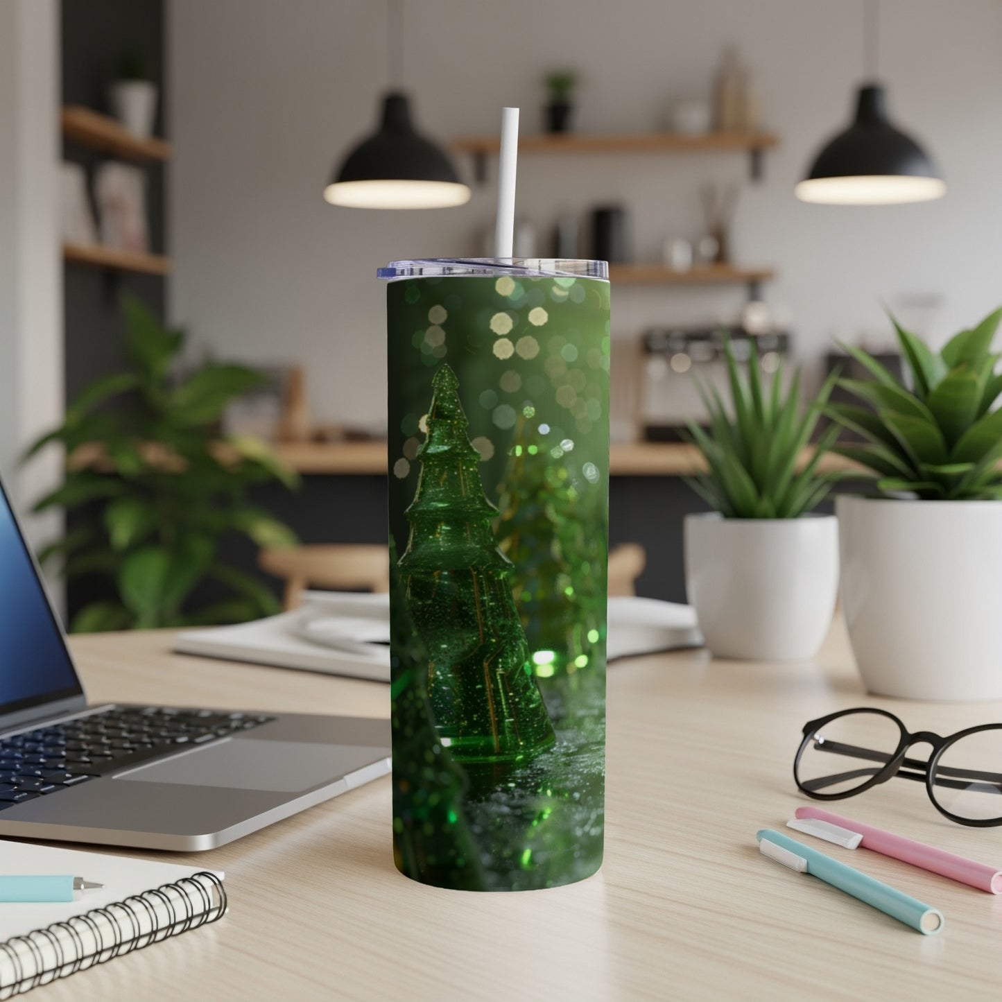 Green Christmas tree tumbler with straw on a desk.
