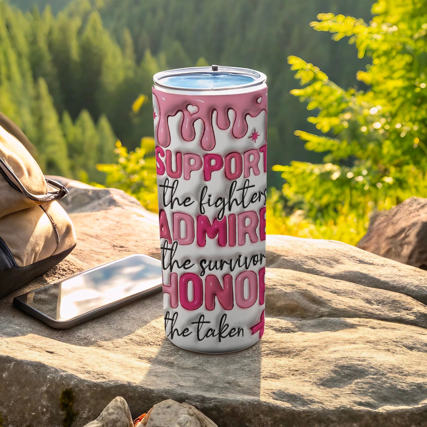 Pink dripping font tumbler with breast cancer awareness text on rocks.