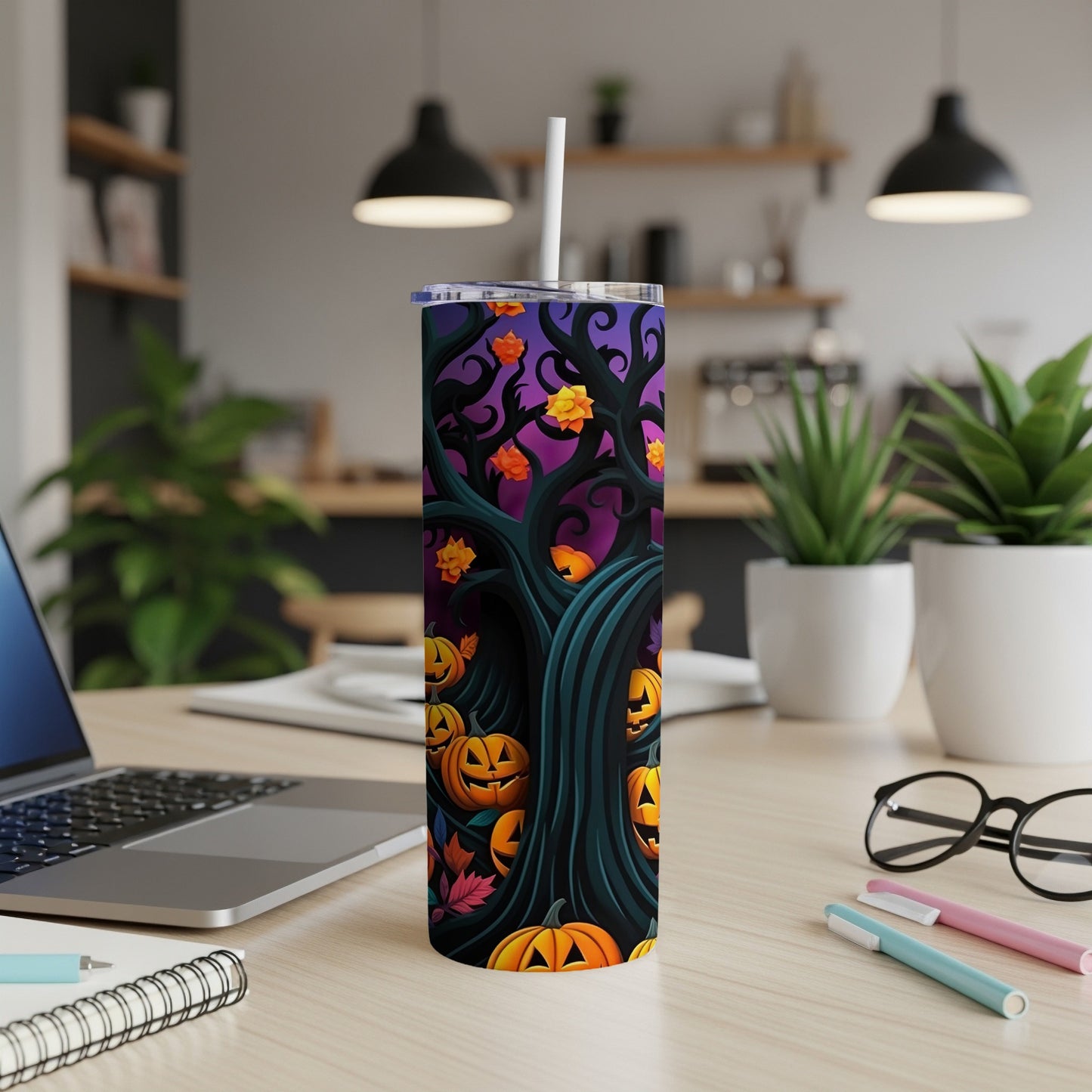 Tumbler with a Halloween design of carved pumpkins and spooky trees on a purple background.