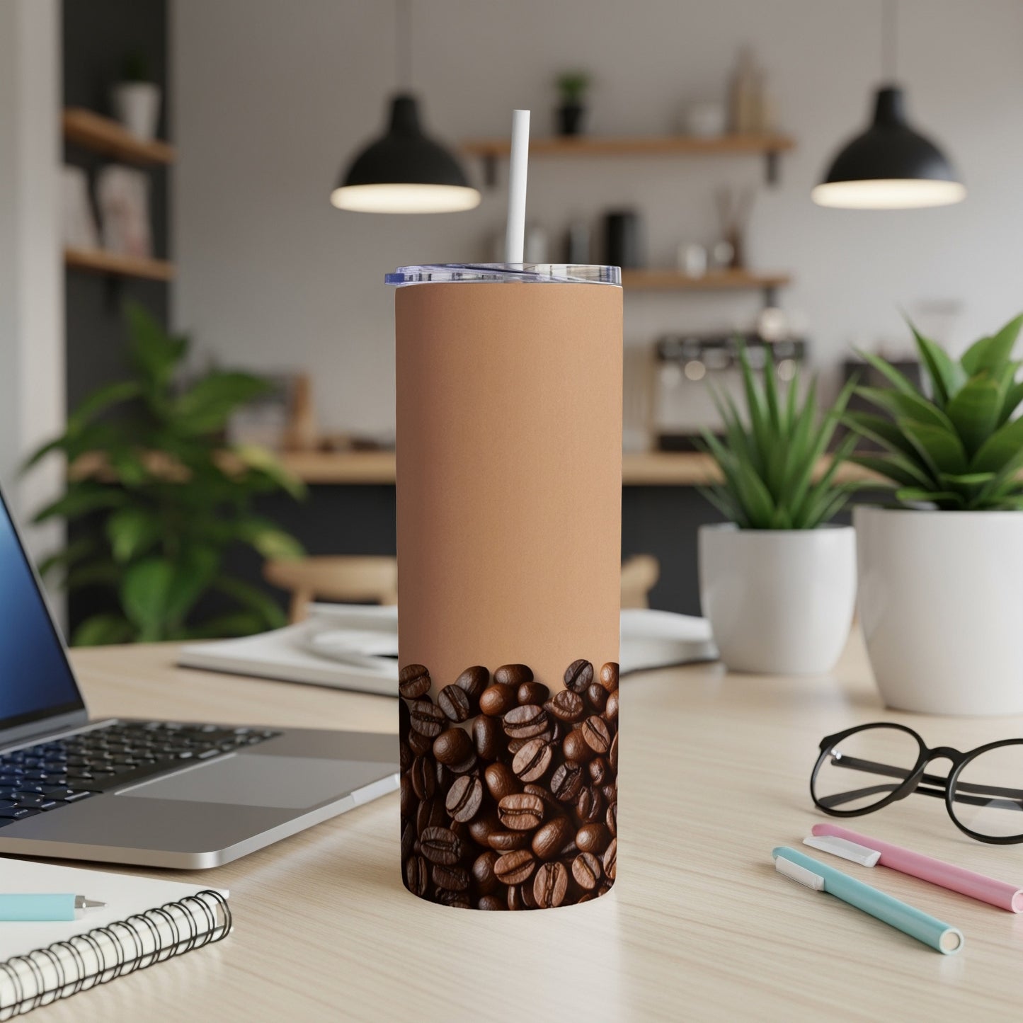 Brown coffee cup with roasted beans and a straw on a desk.