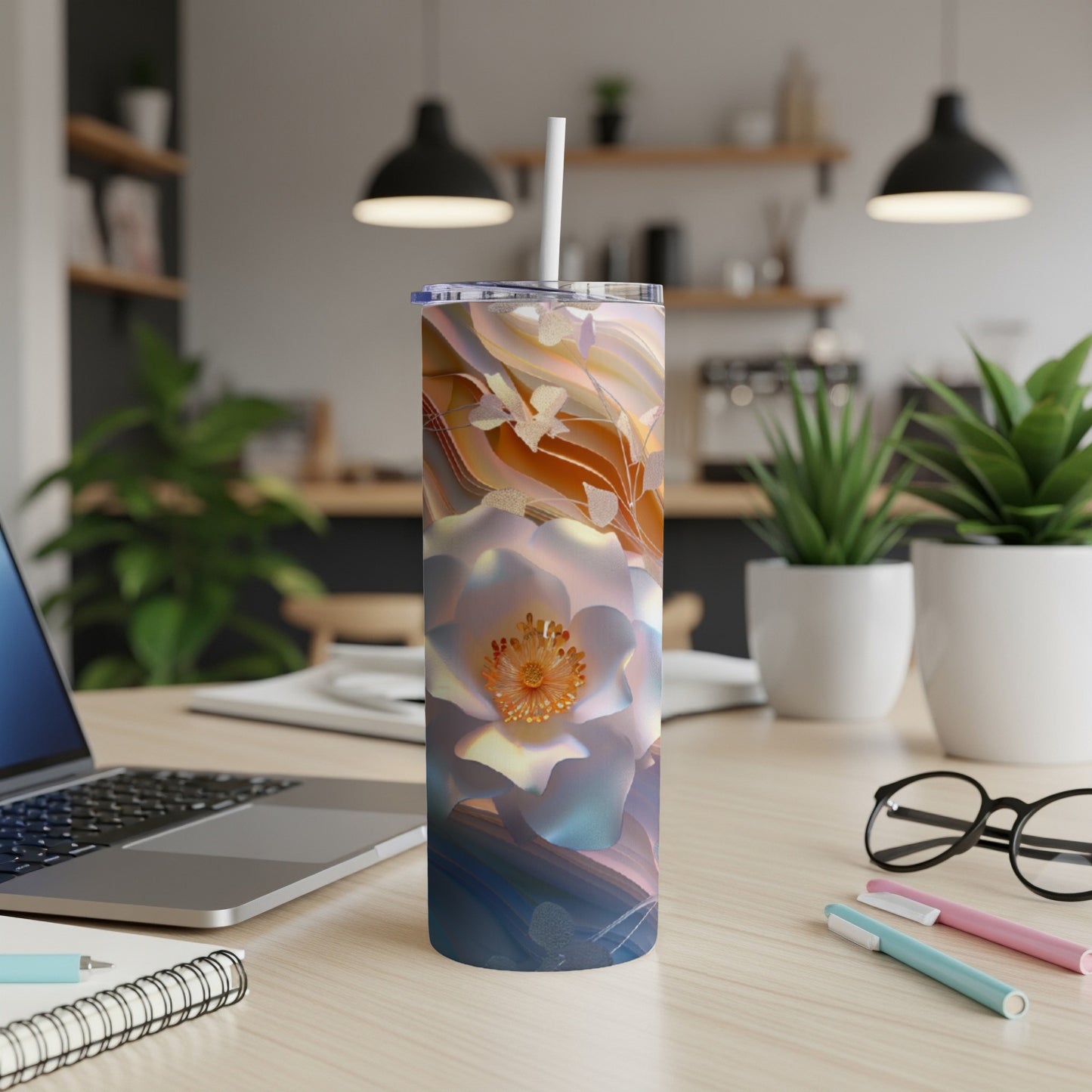 White floral pattern on a white tumbler with a straw, on a desk.