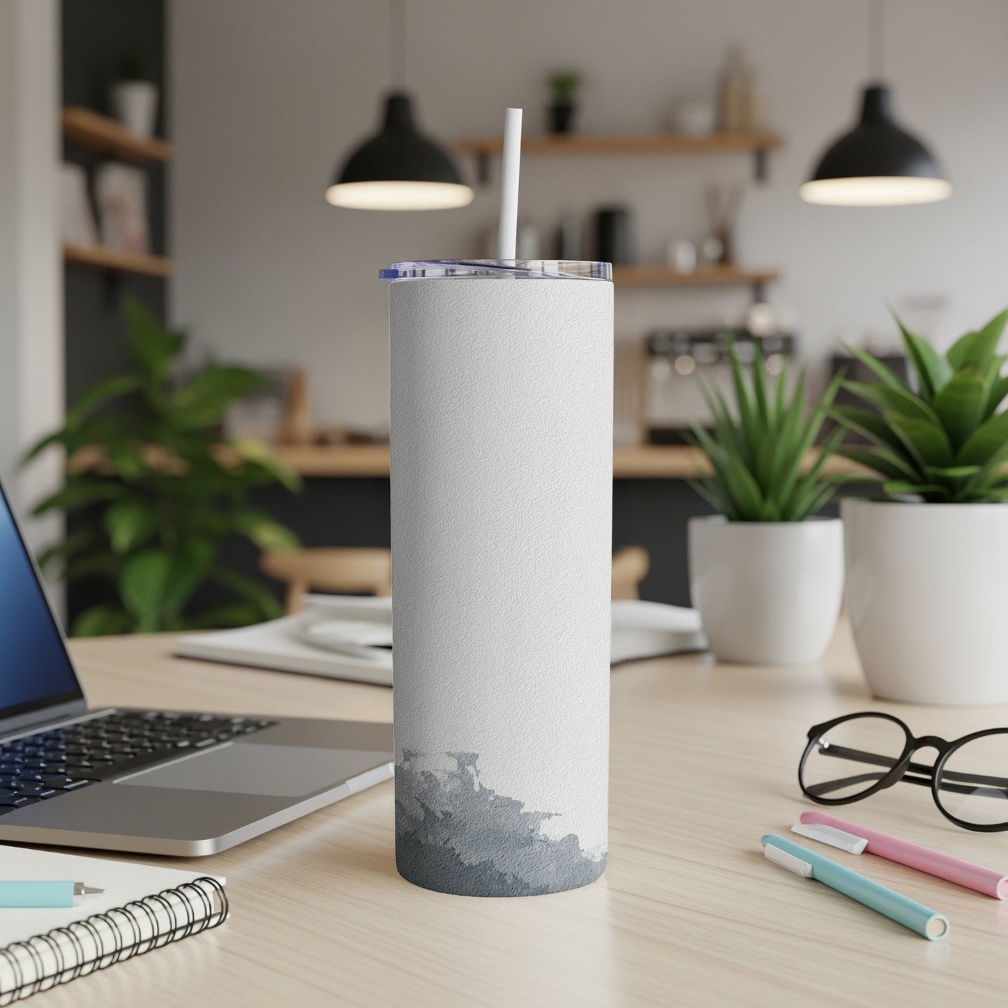 White textured tumbler with a grey abstract mountain design on a desk.