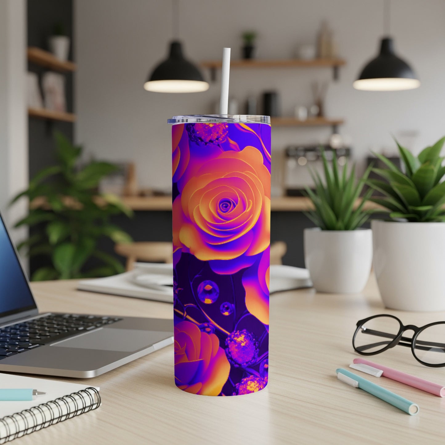 Purple and orange floral tumbler with straw on a desk.