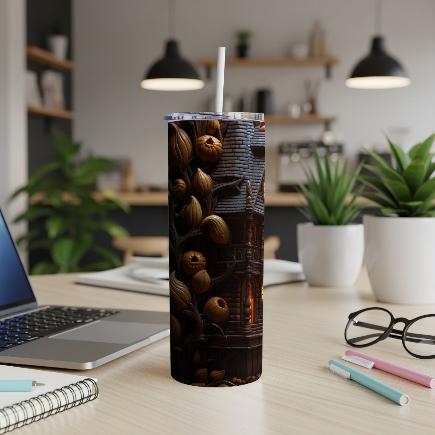 Tumbler with Halloween haunted house and pumpkin design, featuring a white straw.
