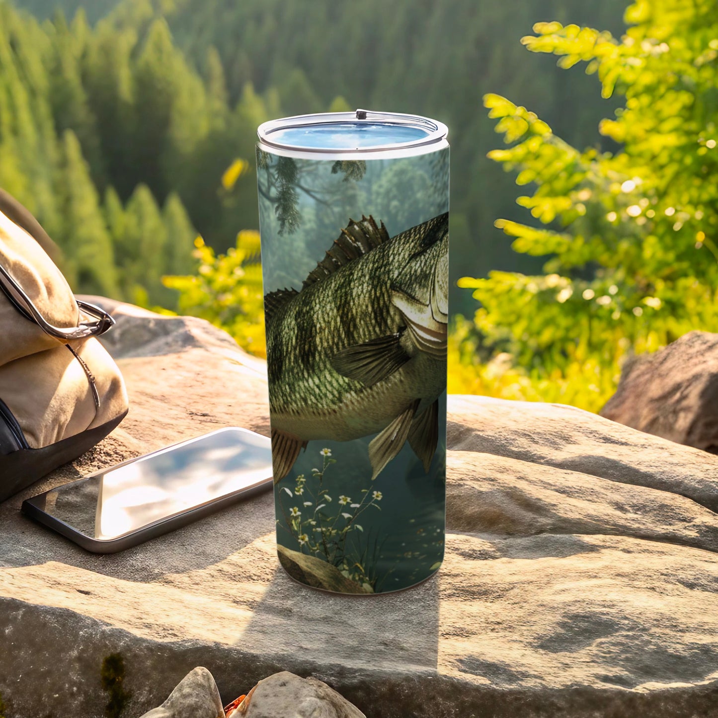 Tall tumbler with a largemouth bass design on a rocky, wooded outdoor setting.