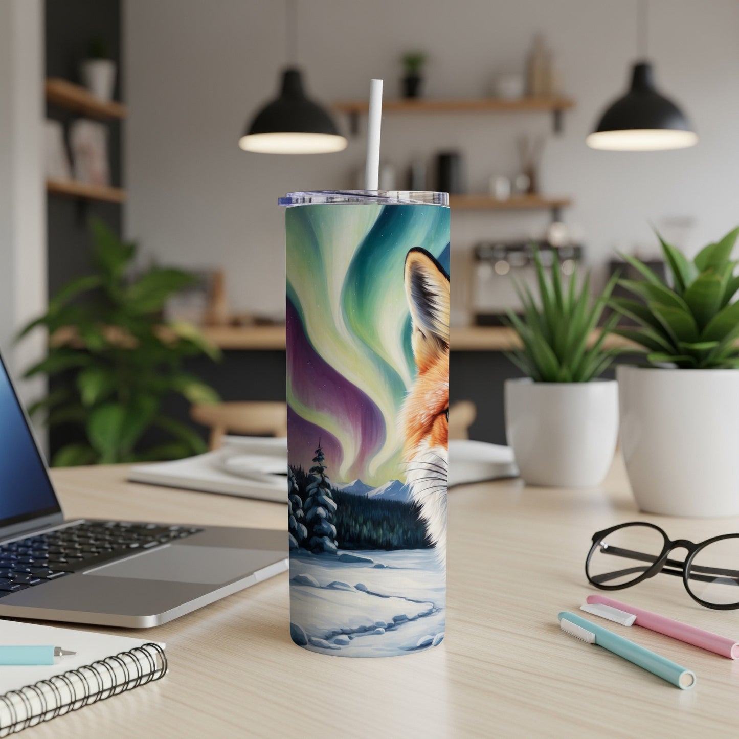 Tumbler with fox and aurora borealis design on a desk.