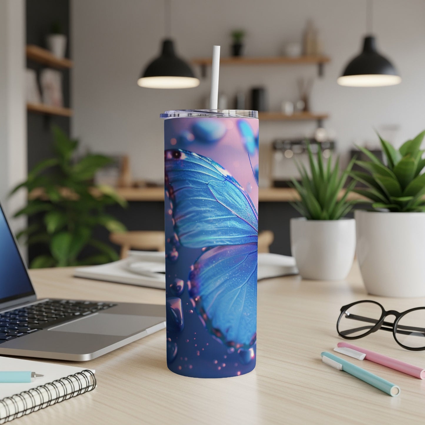 Blue butterfly tumbler with straw on a desk.