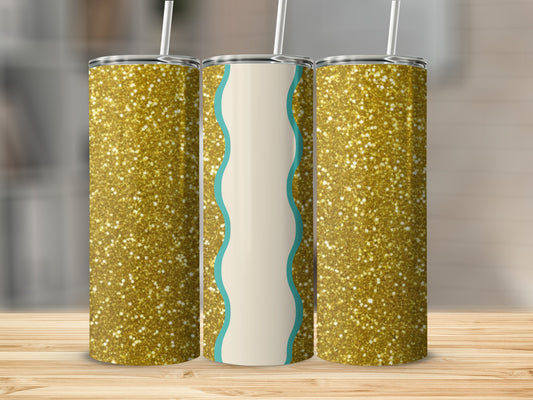 Three glittery gold tumblers with cream and teal wavy accents on a wooden surface.