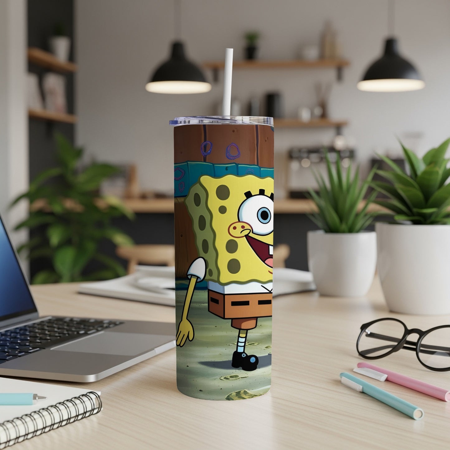 SpongeBob SquarePants tumbler with straw, standing on a desk.
