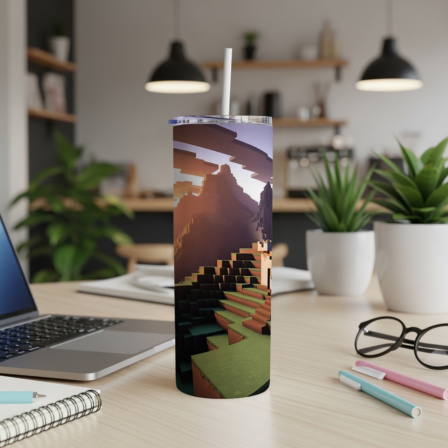 Minecraft world landscape on a tumbler with straw on a desk.