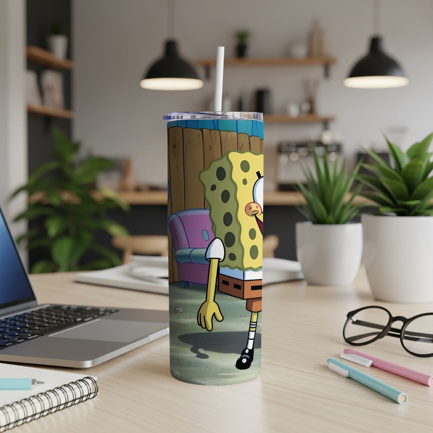 SpongeBob SquarePants character on a tumbler with a straw, on a desk.