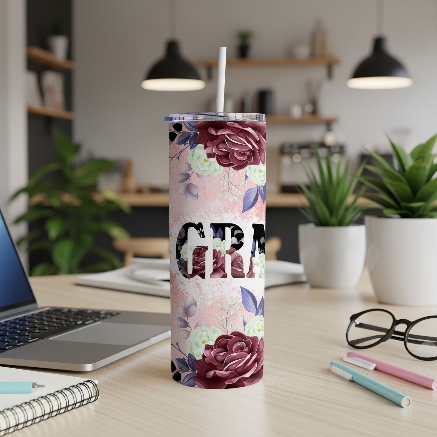 Tall tumbler with floral pattern and "Grama" text, with a straw.