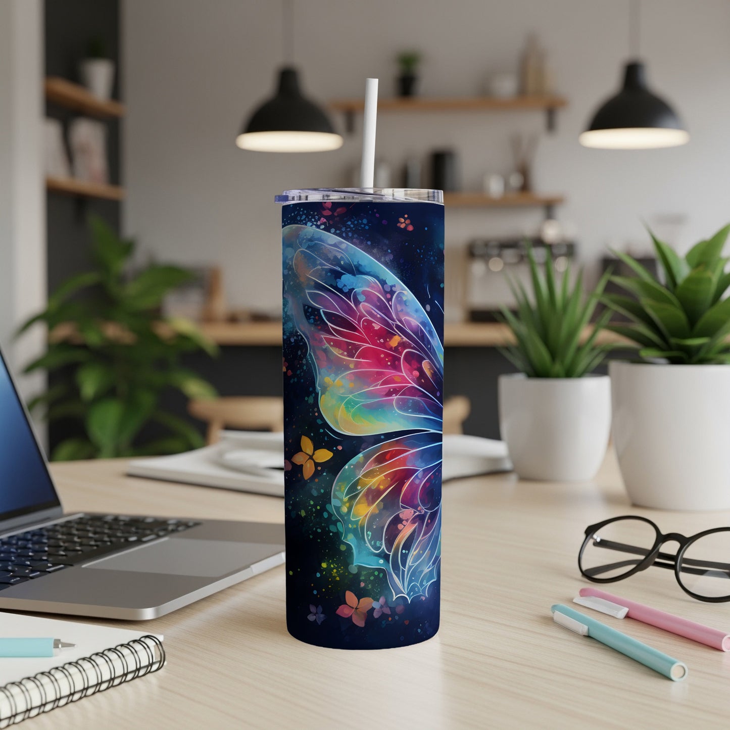 Tumbler with colorful butterfly wing design on a desk.