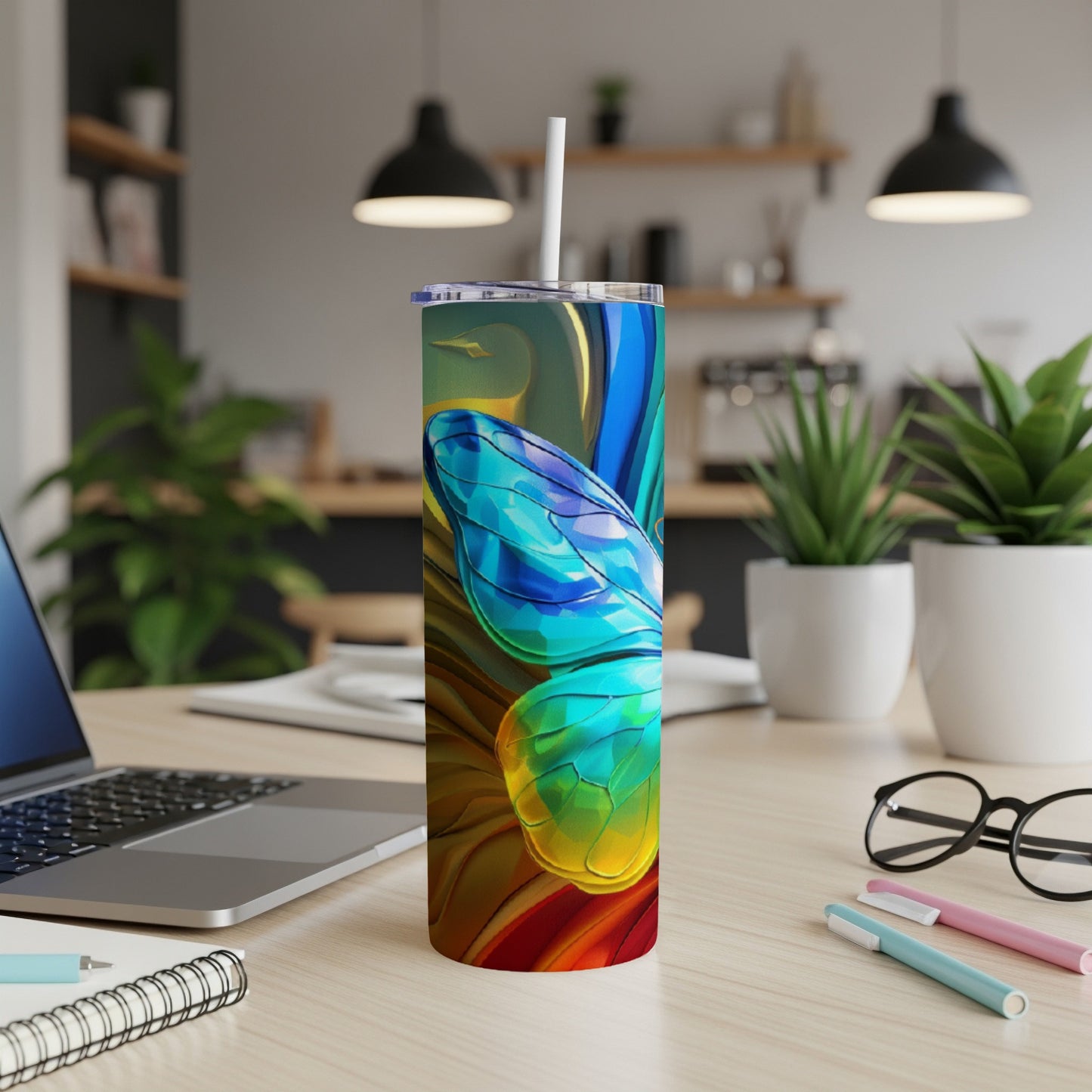 Colorful abstract snake design on a white skinny tumbler with a straw.
