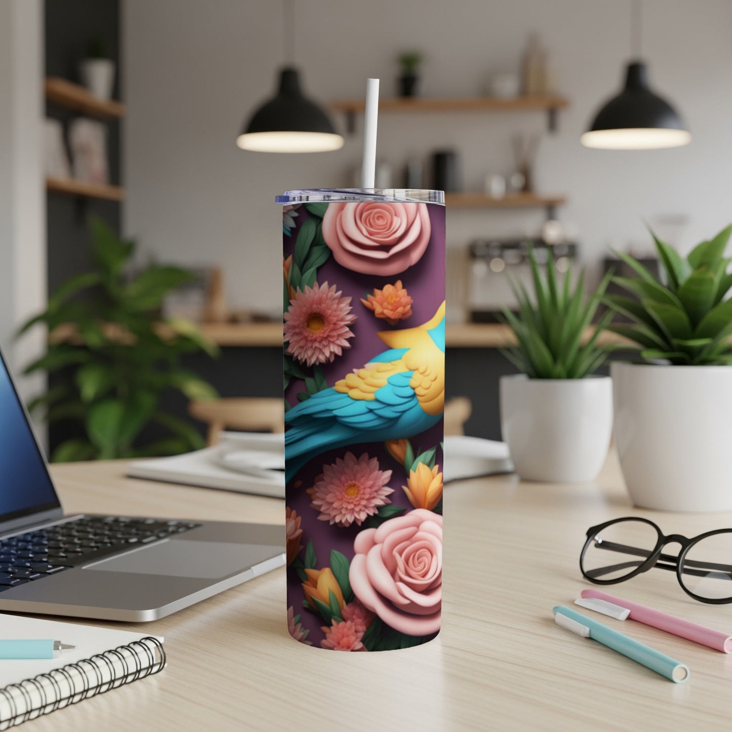 Tumbler with a parrot and flowers design on a desk.