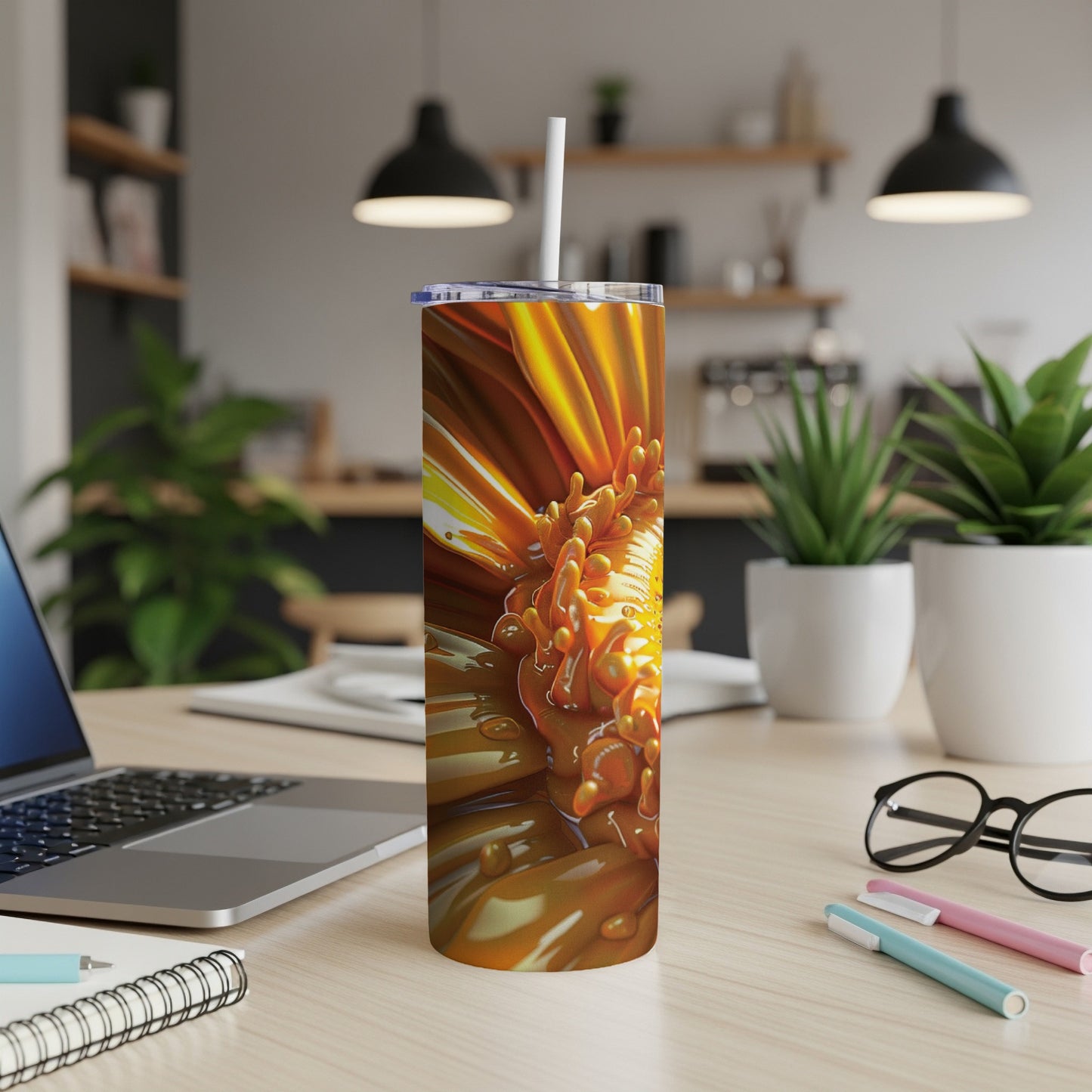Orange flower design on a skinny tumbler with a straw.
