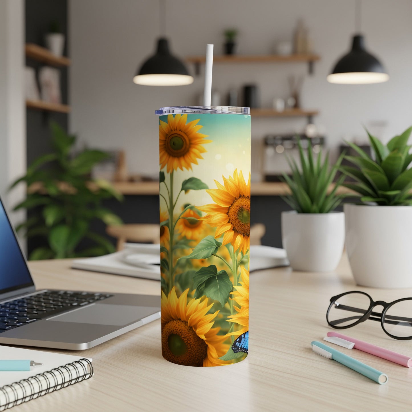 Sunflower tumbler with a blue butterfly design on a desk.