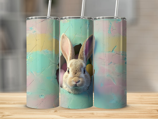 Easter bunny peeking through cracked egg on a tumbler.