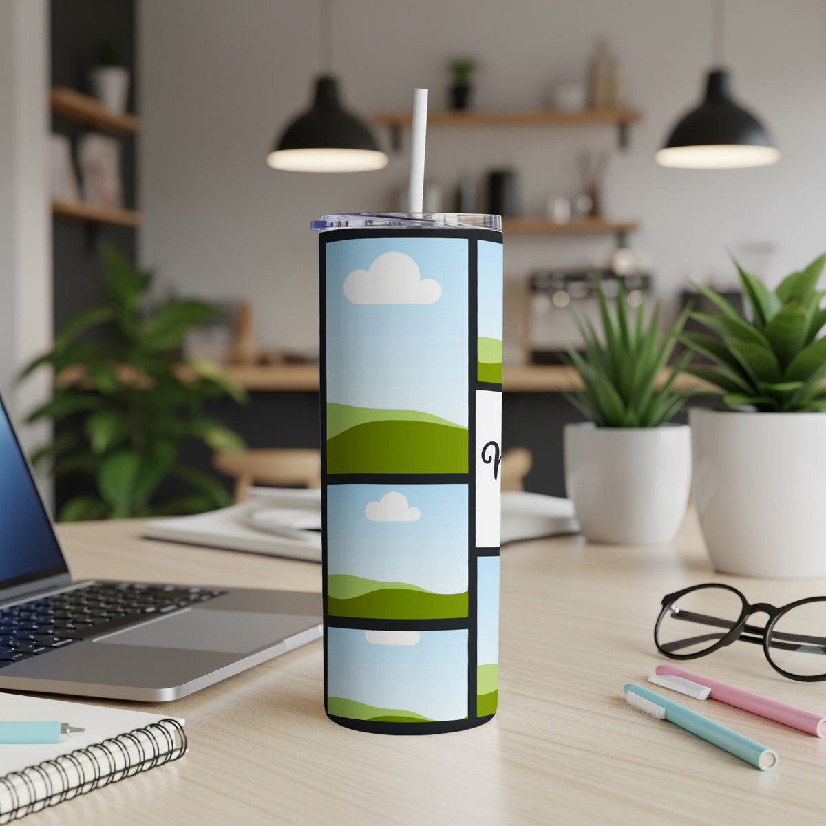 Tumbler with a grid design of green hills and blue sky with clouds.
